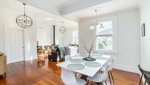 A spacious dining area with a white table, grey placemats, and modern chairs.
