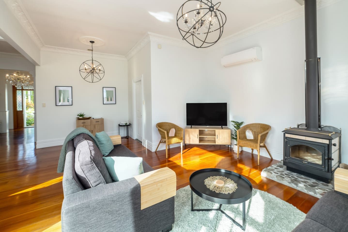 A modern living room with a fireplace, a flat-screen TV, and comfortable seating.