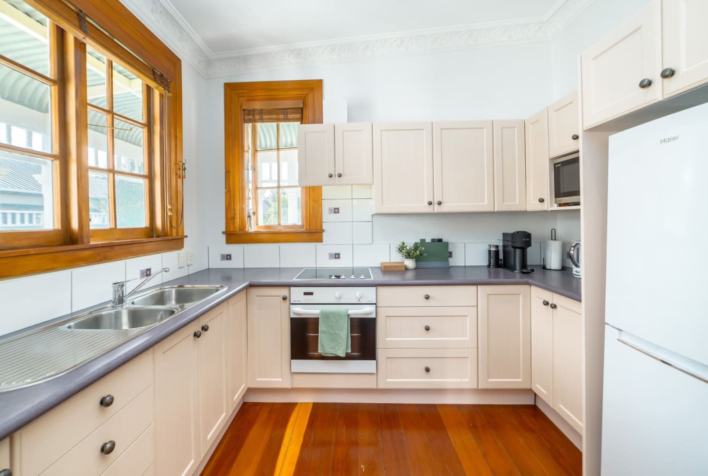 A kitchen with wooden cabinets, a stove, a sink, and a refrigerator.