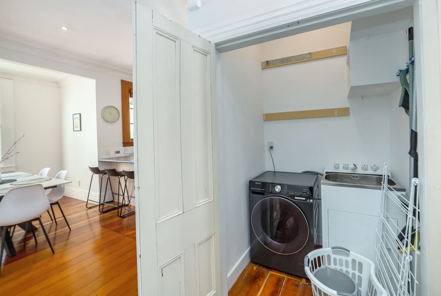 A compact kitchen with a washing machine, a sink, and a drying rack.