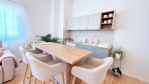 A modern kitchen with a wooden table and four chairs, a sink, and cabinets above the counter. - Luna Serene Garden House | Jacuzzi (Zadar)