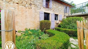 A stone house with a wooden gate, a well-maintained garden, and a sign indicating it's a Gites de France property. - Gîtes de France® - Bri-Gîte (SAINT MEDARD)