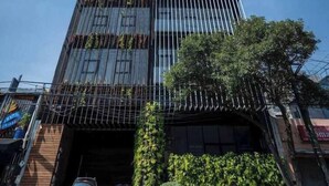 A modern building with a glass facade and a covered entrance. - Chic 2-bedroom apartment with WiFi, fitness room, valet parking in CDMX (Ciudad de México)