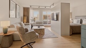 A modern living room with a sofa, armchairs, a coffee table, and a TV. - Belmont Residences (Opfikon)