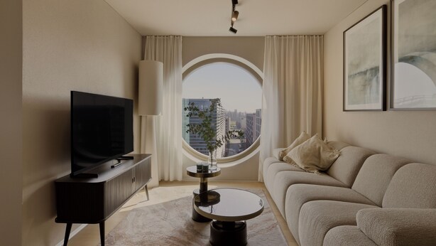 A modern living room with a TV, a round table, a sofa, a large window with curtains, and framed artwork on the wall. - Belmont Residences (Opfikon)