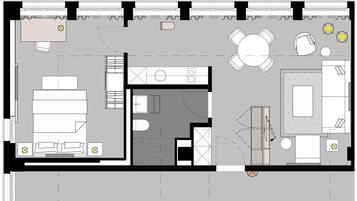 Plano de planta de un hotel con zona de comedor central, varias habitaciones, un baño y una cocina.