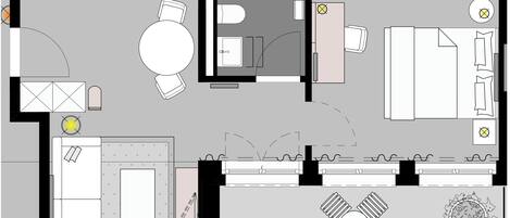 A floor plan of a hotel room with a bed, a desk, a chair, a small table, and a circular seating area.