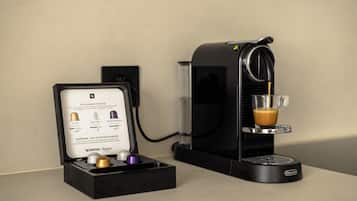 Eine Nespresso-Kaffeemaschine mit einer Glaskanne Kaffee, einem Nespresso-Kapselbehälter und einer wandmontierten Steckdose.