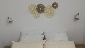Un dormitorio con una cama, dos mesitas de noche y lámparas de pared.