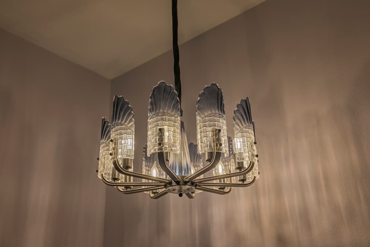 Un candelabro con múltiples pantallas de vidrio y estructura metálica.