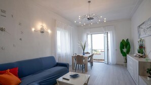 A modern living room with a blue sofa, a coffee table, and a dining area with a table and chairs. - Beautiful home in Corsanico (Corsanico)