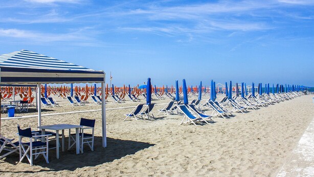 A beach with rows of sun loungers and umbrellas, a covered seating area, and a clear blue sky. - Beautiful home in Corsanico (Corsanico)