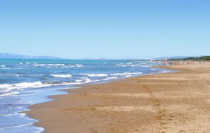A wide sandy beach with gentle waves, a clear sky, and distant mountains. - Stunning home in Suvereto (Suvereto)