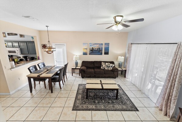 A spacious living area with a dining table, sofa, and ceiling fan. - Closest Unit to Pool & Waterpark - Family Resort Near Disney (Davenport)