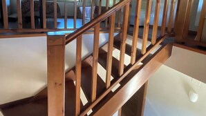Un escalier en bois, doté d’une main courante, mène à l’étage supérieur.