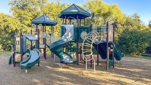 A playground with a slide, climbing structures, and a covered play area.
