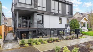 A modern two-story house with a balcony, a front porch, and a well-maintained garden. - 2BR/2BA in the Heart of Ballard (Seattle)
