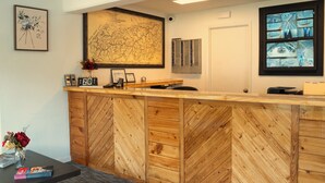 A reception desk with a map, framed artwork, and a security camera. - Sleepy Bear Motel (Gatlinburg)