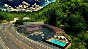 Un motel doté d’une piscine, d’un parking et situé au bord d’une route où circulent des véhicules.