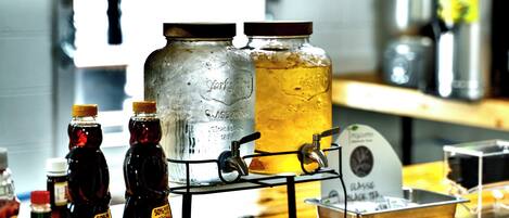 A bar area with a tap, bottles, and a large glass jar.
