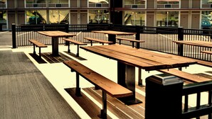Outdoor picnic tables arranged in rows with a building in the background. - Sleepy Bear Motel (Gatlinburg)