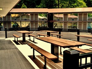 Freistehende Picknicktische in Reihen vor einem Gebäude.