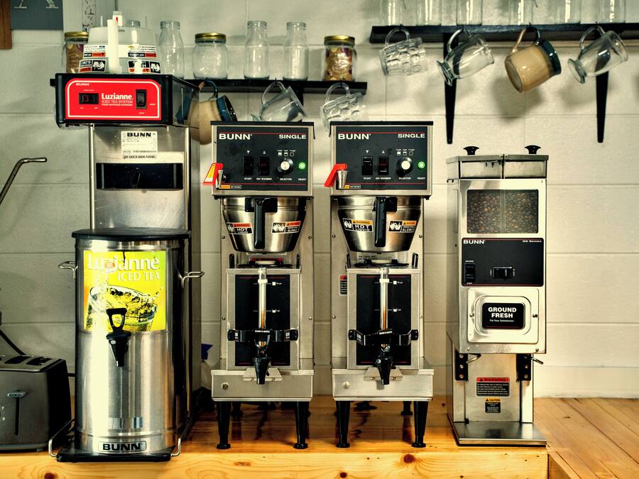 Three Bunn single-serve iced tea machines, a Bunn coffee grinder, and a Bunn single-serve coffee machine.