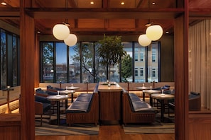 A modern interior with wooden beams, large windows, and seating areas.