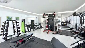 A gym with various exercise equipment, including weight machines, benches, and a squat rack. - 250 sq.ft 3 Studio Apartment w/ Pool & Private Sauna (Dhaka)