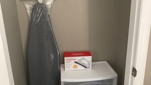 Ett städskåp med förvaringsutrymme, ett upphängningsbart strykjärn och en låda med Sunbeam Classic-strykjärn.