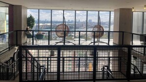 A high-rise hotel interior with a view of a city skyline, large windows, and a modern railing design. - Miami downtown Amazing view rooftop pool & jacuzzi (Miami)