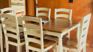Een eetgedeelte met een houten tafel en witte stoelen.