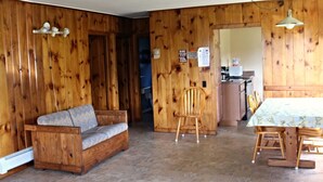 Un intérieur en bois avec un canapé, une table à manger et des chaises.