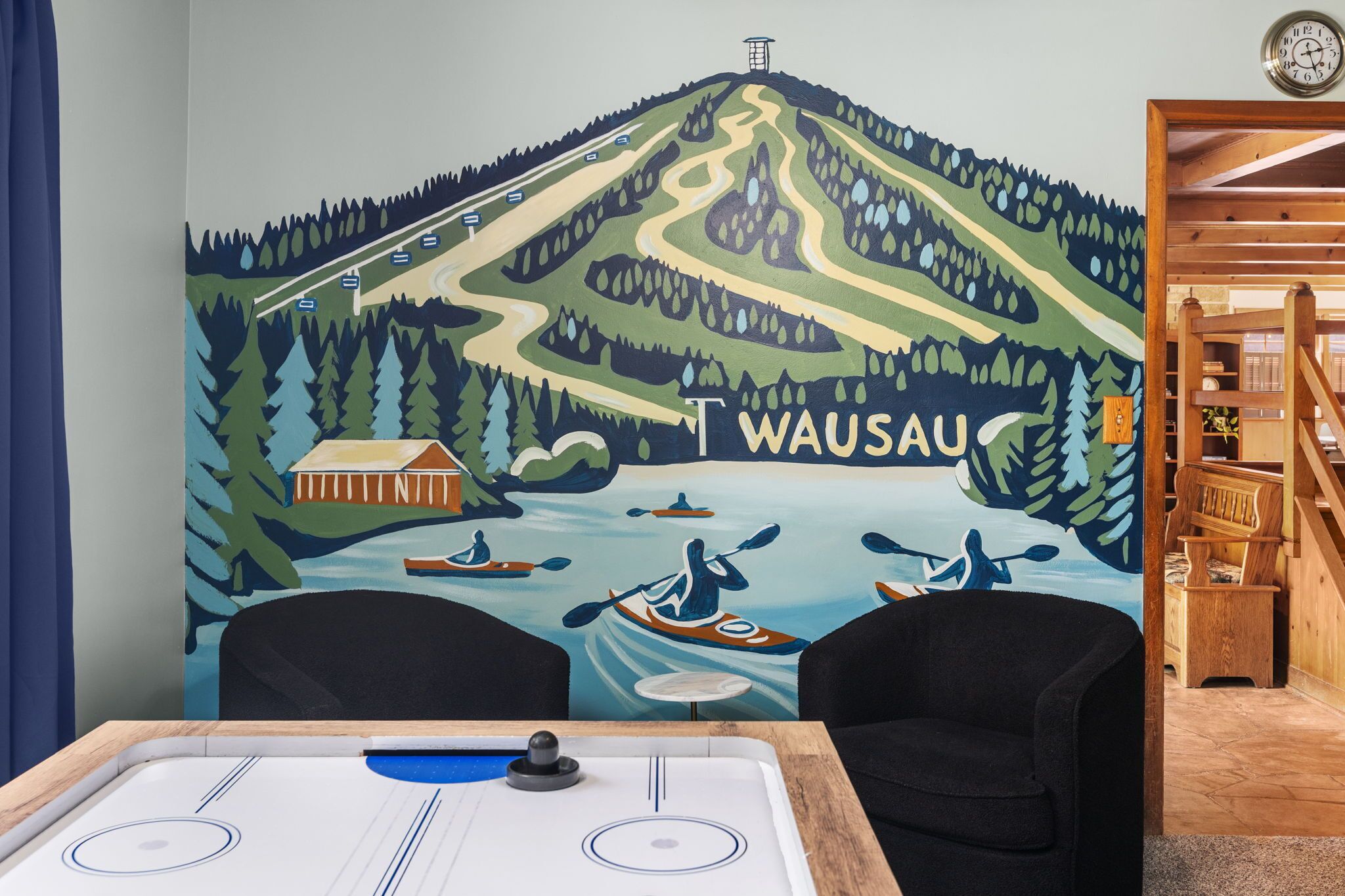 A room with a mural of a mountainous landscape and the word 'WAUSAU' prominently displayed.