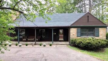 Stroll through the charming covered porch, surrounded by a beautifully manicured lawn and a hedge.