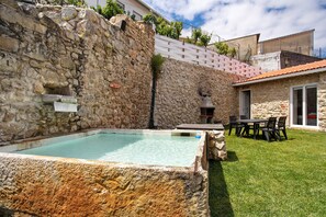 A stone wall, a swimming pool, a grassy yard, and a building with a tiled roof. - Holiday Home 'Castelos Amarelo' with Private Pool, Wi-Fi and Air Conditioning (Santarém)