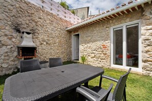 A stone building with a patio table and chairs, a chimney, and a window. - Holiday Home 'Castelos Amarelo' with Private Pool, Wi-Fi and Air Conditioning (Santarém)