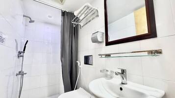 Une salle de bain moderne équipée d’une douche, de toilettes, d’un lavabo et d’un miroir.
