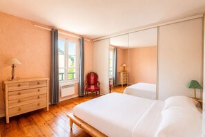 A hotel room with a wooden dresser, a bed, a chair, and a wardrobe. - Hossegor Charming villa with swimming pool, garden and outbuilding for 10 people. (HOSSEGOR)