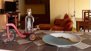 Una sala de estar con una bicicleta roja, una botella de vidrio transparente, un plato azul y una lámpara.