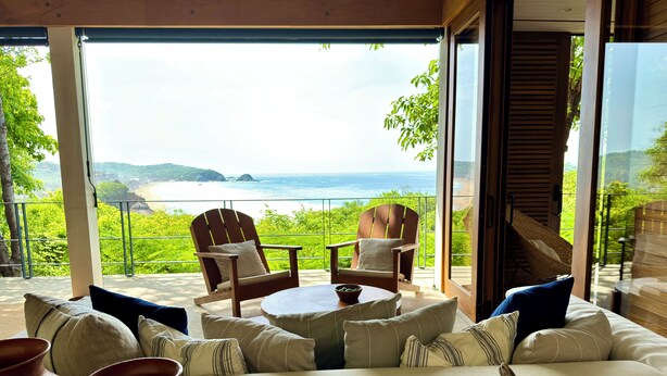 A cozy seating area with a sofa, two chairs, and a table, overlooking a scenic ocean view. - El Guayacan  (Santa Maria Tonameca)