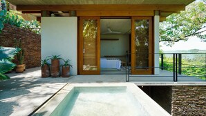 A modern outdoor bathroom with a large bathtub, wooden deck, and potted plants. - El Guayacan  (Santa Maria Tonameca)