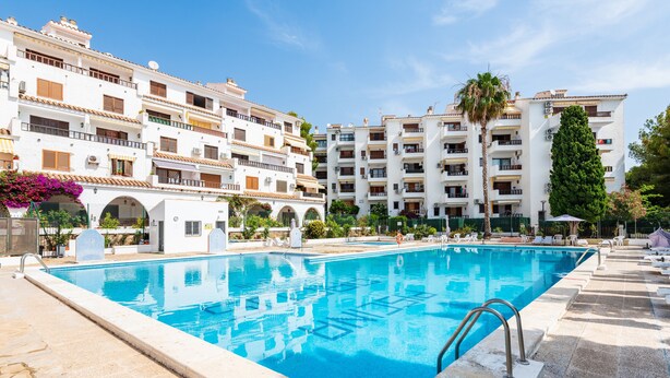 Une piscine à l’eau d’un bleu limpide, entourée d’une terrasse en pierre.