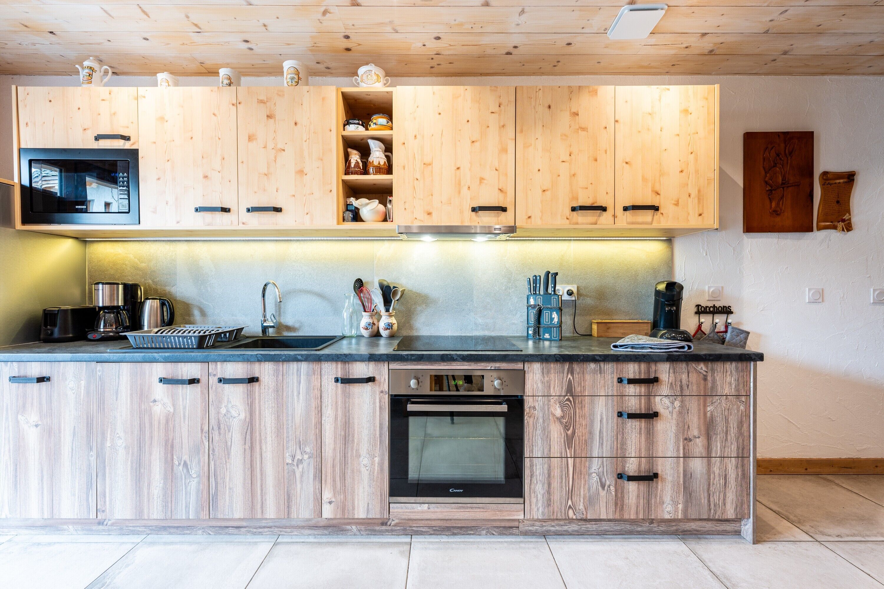 A kitchen with wooden cabinets, a microwave, a coffee maker, and a toaster.