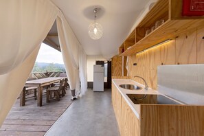 Una cocina moderna con armarios de madera, un lavamanos de acero inoxidable y una zona de comedor con una mesa y sillas.