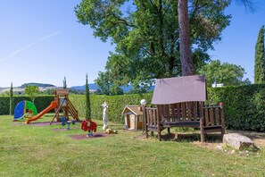 Un parque infantil con tobogán, columpios y una estructura para escalar.