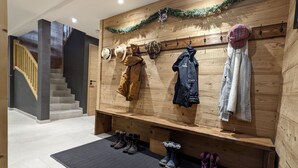 A wooden wall with hats and jackets hanging, a bench with boots, and a staircase in the background. - Chalet "Friwi": Mountain View, Private Terrace & Wi-Fi (Saint-Jean-de-Sixt)