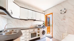 Eine moderne Küche mit Spüle, Mikrowelle, Backofen und Waschmaschine.