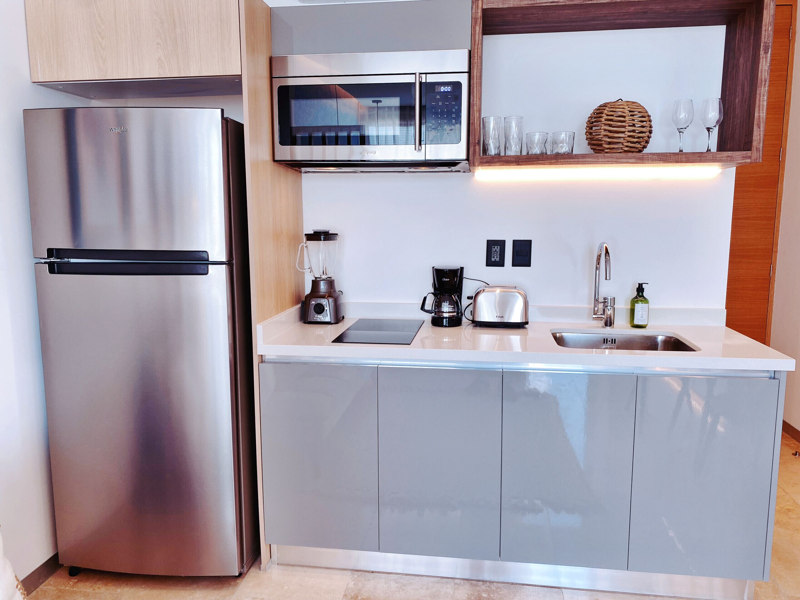 Une cuisine moderne équipée d’appareils électroménagers en acier inoxydable, d’un four à micro-ondes, d’un grille-pain et d’une machine à café.