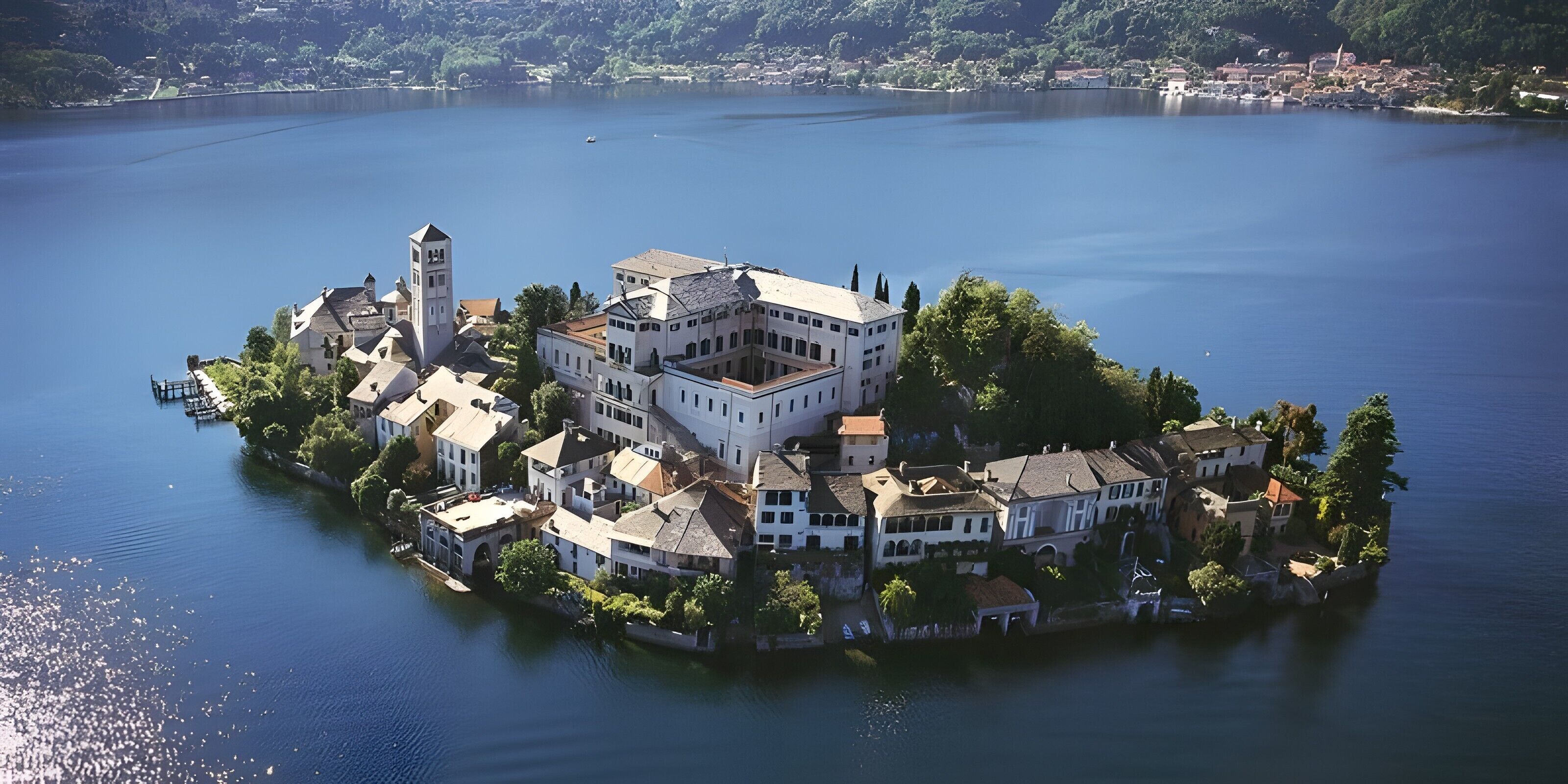 Une propriété située au bord d’un lac, comprenant un bâtiment principal, une tour et plusieurs autres constructions environnantes.